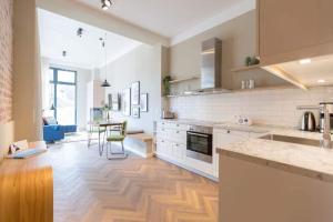cocina con armarios blancos y suelo de madera en Villa Bellevue App 04, en Heringsdorf
