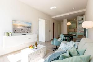 ein Wohnzimmer mit einem Sofa und einem Tisch in der Unterkunft Strandresidenz Else Marie, App. 3.7 in Ahlbeck