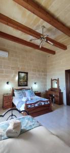 a bedroom with two beds and a ceiling fan at Warda Accommodation in Xewkija