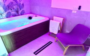 ein lila Badezimmer mit einem Stuhl und einer Badewanne in der Unterkunft Il Casale San Vito in San Vito lo Capo