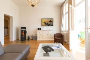 uma sala de estar com um sofá e uma lareira em Villa Saphira App 09 em Heringsdorf