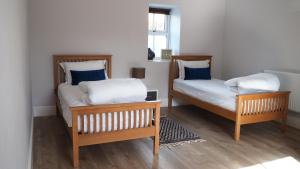 a bedroom with two beds with blue and white pillows at The Inn Keeper in Cranswick