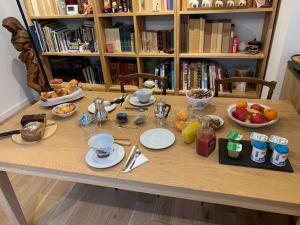 une table avec des assiettes et des bols de nourriture dans l'établissement Chambre d'Hôtes Les Petits Oiseaux, à Nantes