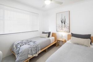 a bedroom with two beds and a picture on the wall at Freddies - pet friendly! last minute discount! in Gold Coast