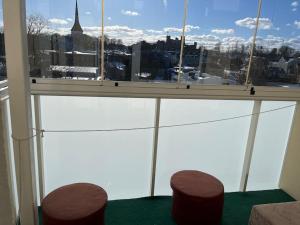 a window with two stools and a view of a city at Lai Apartment in City center of Rakvere in Rakvere