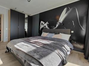 a bedroom with a large bed with a black wall at Lai Apartment in City center of Rakvere in Rakvere