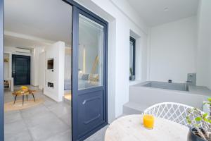 George & Joanna Suites Santorini في فيرا: غرفة بها باب أزرق وطاولة
