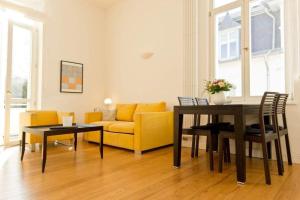 ein Wohnzimmer mit einem gelben Sofa und einem Tisch in der Unterkunft Villa Artemis, 05 Saloniki in Bansin