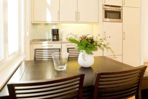eine Küche mit einem Tisch und einer Blumenvase darauf in der Unterkunft Villa Artemis, 05 Saloniki in Bansin