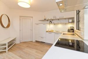 eine Küche mit weißen Schränken und einer Arbeitsplatte in der Unterkunft Villa Bettina, App. 01 in Heringsdorf