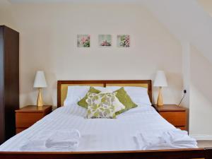 a bedroom with a white bed with pillows and two lamps at Seaview in Oban