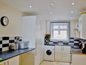 a kitchen with a washing machine and a microwave at Seaview in Oban