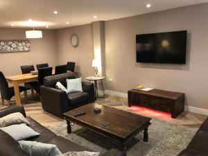 a living room with a couch and a table and a television at Modern 3 Bed Barn Conversion in Great Urswick in Great Urswick