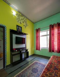 a living room with a television and green walls at Hotel Prem Villas Pushkar in Pushkar
