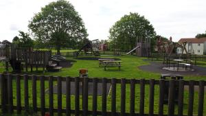 a park with a playground with tables and benches at The Inn Keeper in Cranswick