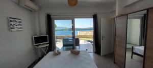 una camera con letto, TV e balcone di Lefkada Unique Sea View Apartment a Nydri