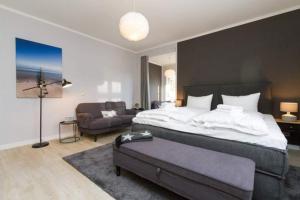 Un dormitorio con una cama grande y un sofá. en Villa Brunnenstraße, App 1, en Heringsdorf