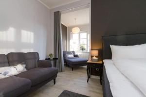 una sala de estar con una cama y un sofá en Villa Brunnenstraße, App 1, en Heringsdorf