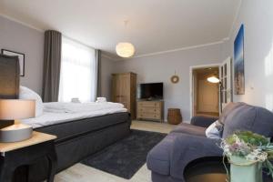 una habitación de hotel con una cama y un sofá en Villa Brunnenstraße, App 1, en Heringsdorf 7 fotos más