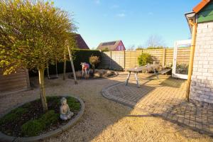 a small garden with a table and a tree at Huisje 11 Wemeldinge in Wemeldinge