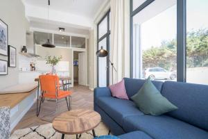 un soggiorno con divano blu e tavolo di Villa Bellevue App 02 a Heringsdorf