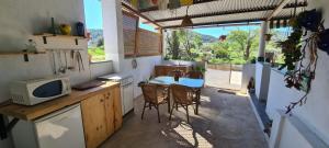 uma pequena cozinha com uma mesa e um micro-ondas em Finca los Natachos em Coín