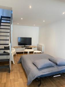een slaapkamer met een bed en een televisie en een trap bij Le Duplex du Cours de Verdun in Arras