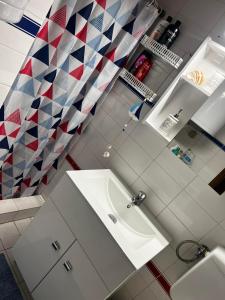 a bathroom with a white sink and akered shower curtain at Sani Garden House in Sani Beach