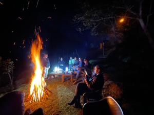a group of people sitting around a fire at The woodswalk Treks and tours in Pahalgām