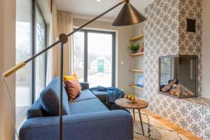 sala de estar con sofá azul y chimenea en Villa Bellevue App 06, en Heringsdorf