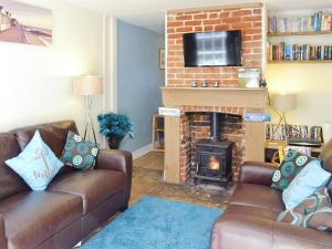 a living room with two couches and a fireplace at Seashells in Cromer
