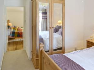 a bedroom with a bed and a mirror at Seashells in Cromer