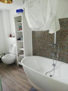 a white bath tub in a bathroom with a toilet at Strandhaus in Neubukow
