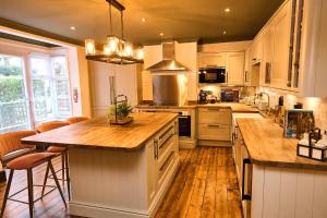 a kitchen with white cabinets and a wooden floor at Little Hayes, Lyndhurst in Lyndhurst