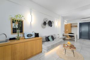 George & Joanna Suites Santorini في فيرا: غرفة معيشة مع أريكة وطاولة