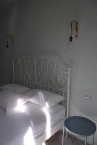 ヴィーコ・デル・ガルガーノにあるGarganoMareBorghi ospitalità diffusaのベッドルーム1室(ベッド1台、青いテーブル付)