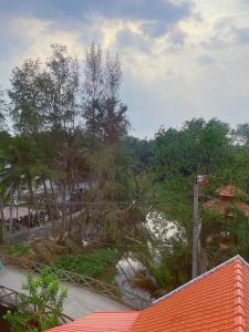 uma vista para um jardim com árvores e água em Khách sạn Thanh Bình Bến Lức em Bến Lức