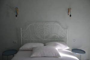 ヴィーコ・デル・ガルガーノにあるGarganoMareBorghi ospitalità diffusaの白いベッド(枕2つ、テーブル2台付)