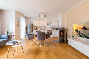 a kitchen and living room with a table and chairs at Quartier am Waldschloss App 01 in Heringsdorf