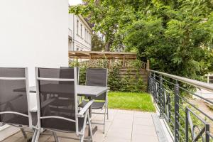 a patio with chairs and a table on a balcony at Quartier am Waldschloss App 01 in Heringsdorf