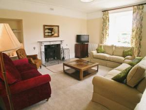 a living room with couches and a fire place at Armswell House in Ansty