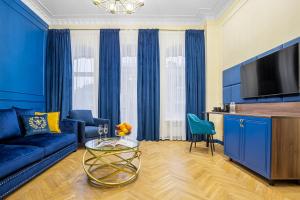a living room with a blue couch and a tv at Queen Bee in Kyiv