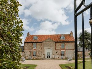 an exterior view of a large stone house with a courtyard at Farmhouse - Ukc6630 in Pentney