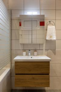 La salle de bains est pourvue d'un lavabo blanc et d'une baignoire. dans l'établissement Strat's City Loft, à La Canée