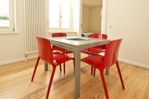 une table avec quatre chaises rouges et une table blanche avec ahibition dans l'établissement Villa Astrid, T3 Anklam, à Bansin