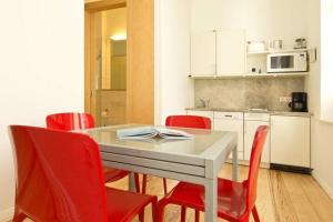 une salle à manger avec des chaises rouges et une table blanche dans l'établissement Villa Astrid, T3 Anklam, à Bansin