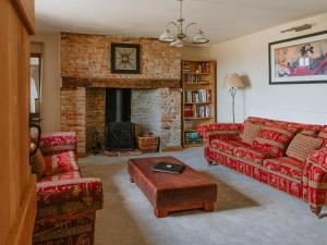 a living room with red couches and a fireplace at Farmhouse - Ukc6630 in Pentney