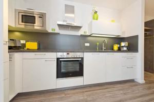 uma cozinha com armários brancos e um micro-ondas em Ostseedomizil Bansin App 2 1 em Bansin