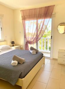 um quarto com uma cama e uma grande janela em Villa Oceania em Agia Napa