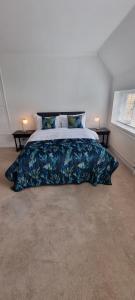 - une chambre avec un grand lit et une couverture bleue dans l'établissement Yew Tree House, à Woodstock